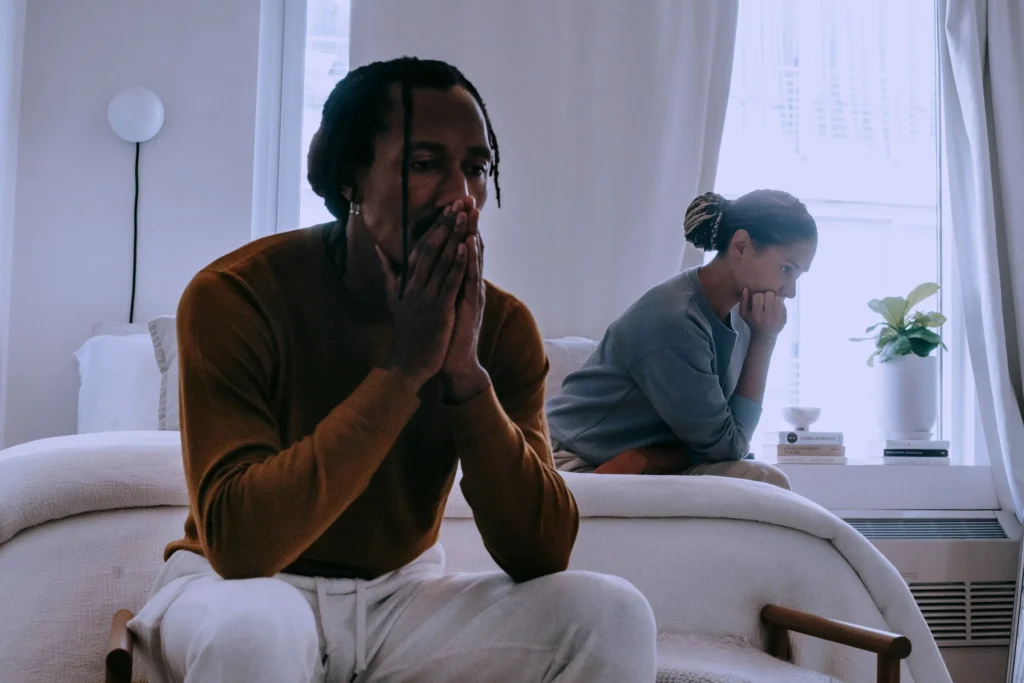 A photo of a couple sitting on the bed after an argument